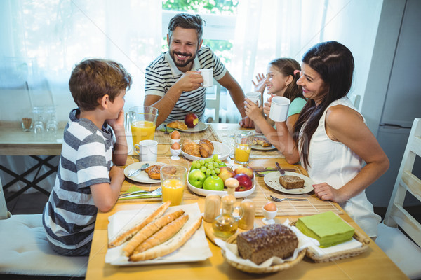 Happy family talking to each other while having breakfast together Stock photo © wavebreak_media