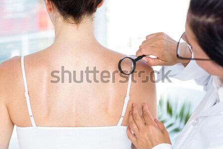 Dermatolog mol femeie pacient lupa Imagine de stoc © wavebreak_media