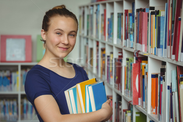 Portré iskolás lány áll boglya könyvek könyvtár Stock fotó © wavebreak_media