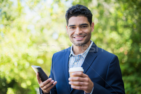 Om de afaceri disponibil ceaşcă de cafea telefon mobil portret Imagine de stoc © wavebreak_media