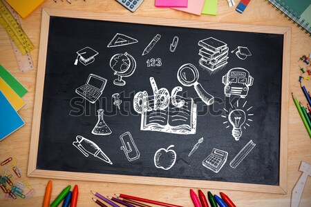 Books by slate with desk organizer and apple on wooden table against blue background Stock photo © wavebreak_media