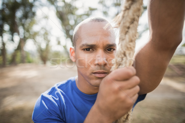 Portrait of fit man climbing rope during obstacle course Stock photo © wavebreak_media