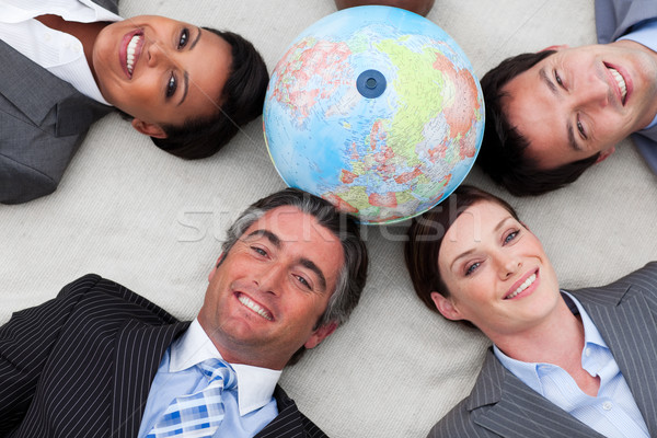 Business people lying on the floor around a terrestrial globe  Stock photo © wavebreak_media