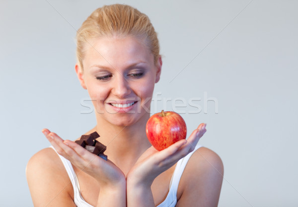 Stock photo: Friendly woman holding chocolate and apple focus on woman 