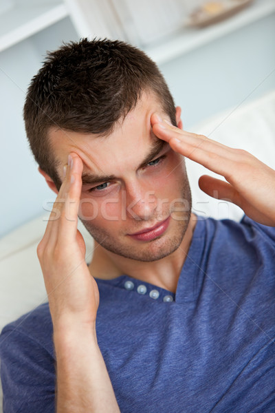 Depressed man having a headache in the living room Stock photo © wavebreak_media