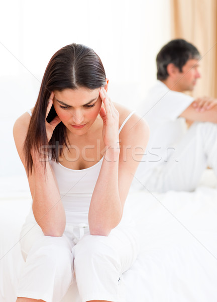 Stock photo: Distress couple sitting sitting separately on their bed after having a row 