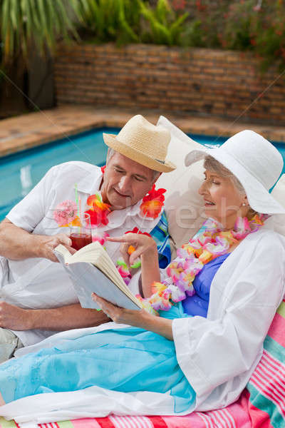 Mature woman reading a book while her husband is drinking a cocktail Stock photo © wavebreak_media
