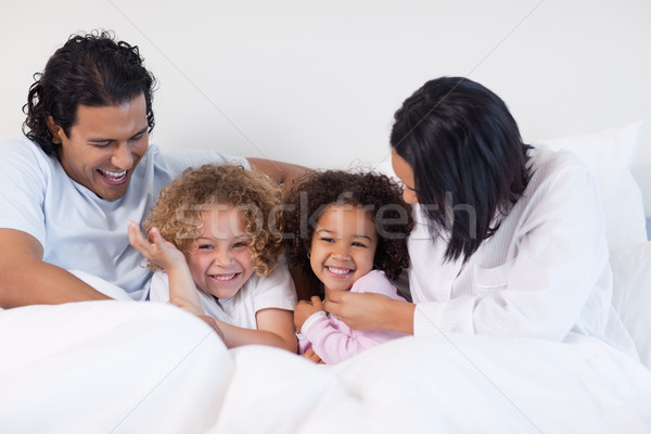 Sorridente jovem família sessão cama amor Foto stock © wavebreak_media