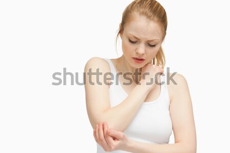 Young woman touching her elbow against white background Stock photo © wavebreak_media