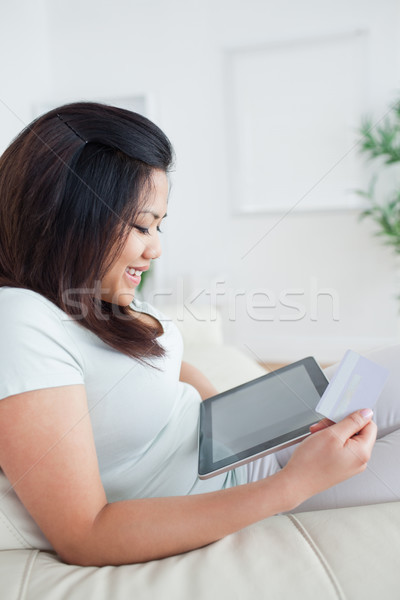 Woman looking at a tactile tablet while sitting on a couch in a living room Stock photo © wavebreak_media