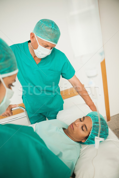 Stock photo: Asleep female patient on a bed in hospital corridor