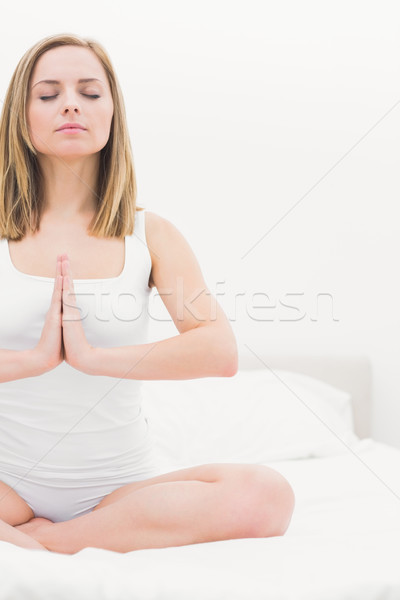 Woman in praying position with eyes closed on bed Stock photo © wavebreak_media