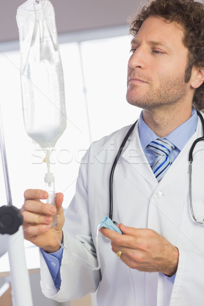 Doctor examining intravenous drip  Stock photo © wavebreak_media