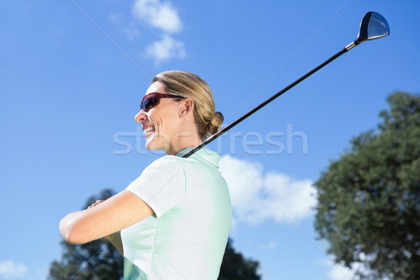 Vrouwelijke golfer permanente club glimlachend Stockfoto © wavebreak_media