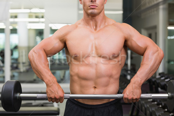 Mid section of a shirtless muscular man lifting barbell Stock photo © wavebreak_media
