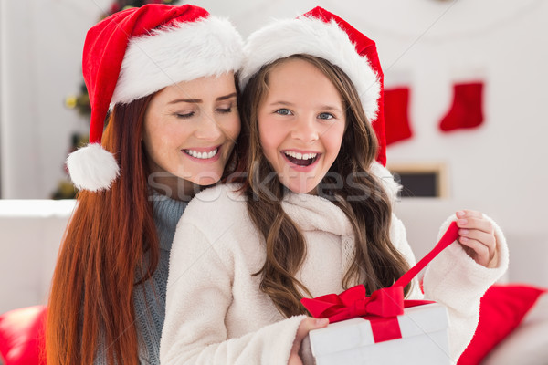 Festive mother and daughter on the couch with gift Stock photo © wavebreak_media