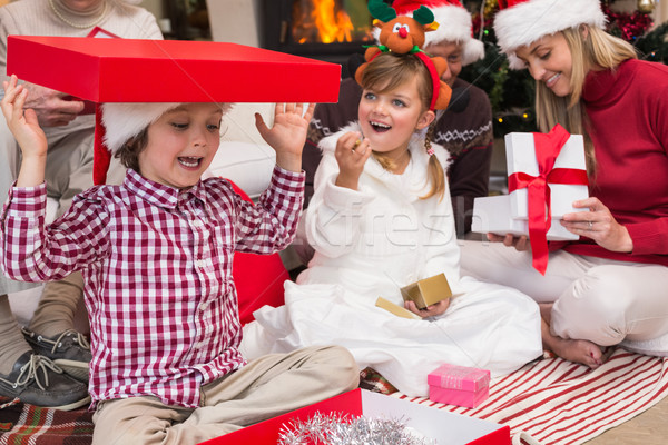 Son playing with a gift sitting on the floor with his family Stock photo © wavebreak_media