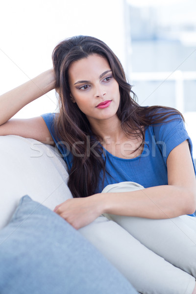 Thoughtful beautiful brunette sitting on the couch Stock photo © wavebreak_media