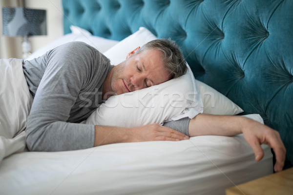 Man sleeping on bed in bedroom Stock photo © wavebreak_media