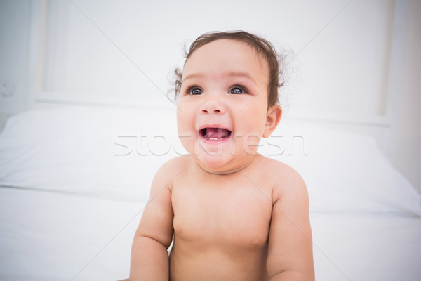 Bonitinho sorridente menina sessão cama casa Foto stock © wavebreak_media