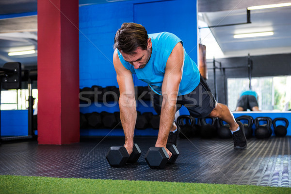 Fiatalember súlyzók tornaterem testmozgás férfi fitnessz Stock fotó © wavebreak_media