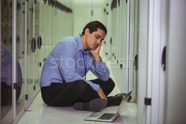 Stressed technician sitting on floor and looking at laptop Stock photo © wavebreak_media