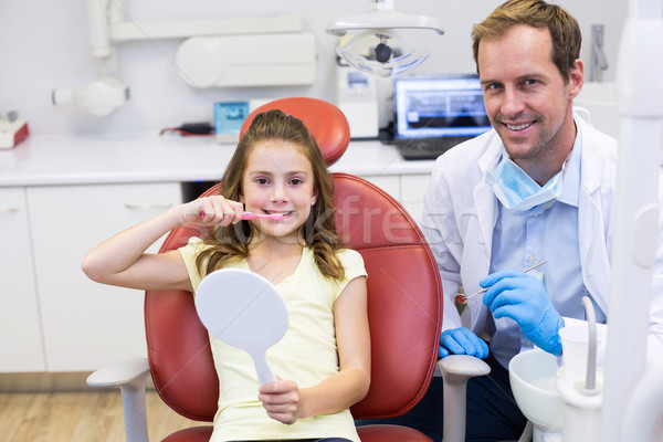 Smiling young patient with a dentist in dental clinic Stock photo © wavebreak_media