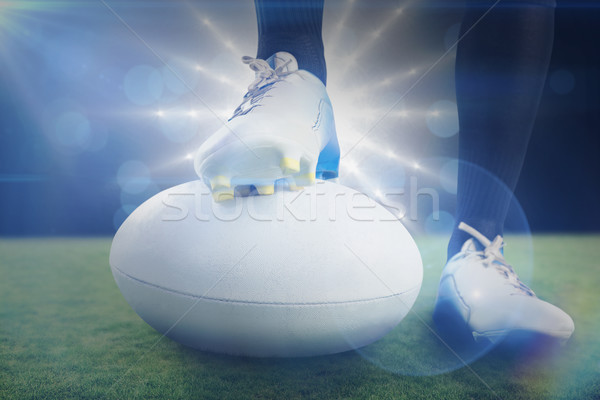 Stock photo: Composite image of rugby player posing feet on the ball