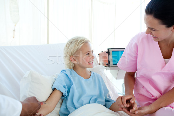 Young nurse smiling to a little girl who receiving an injection Stock photo © wavebreak_media