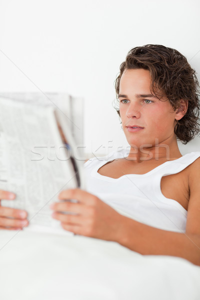 Portret młody człowiek czytania gazety sypialni świetle Zdjęcia stock © wavebreak_media