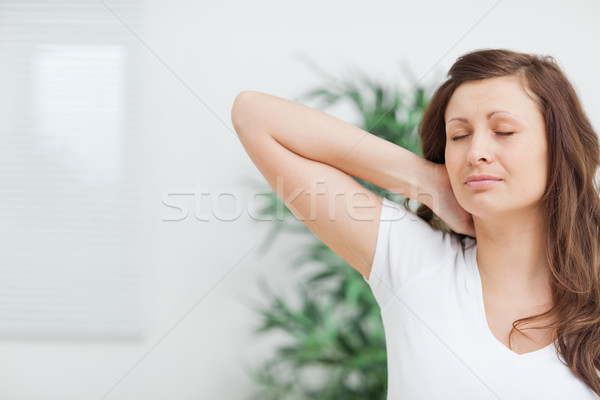 Woman placing her hand on her painful neck in a room Stock photo © wavebreak_media