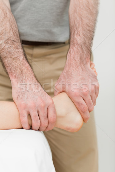 Osteopath manipulating the ankle of a patient in a room Stock photo © wavebreak_media