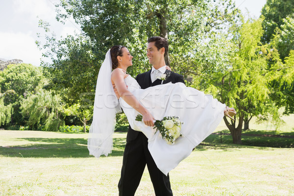 Groom carrying bride in arms at garden Stock photo © wavebreak_media