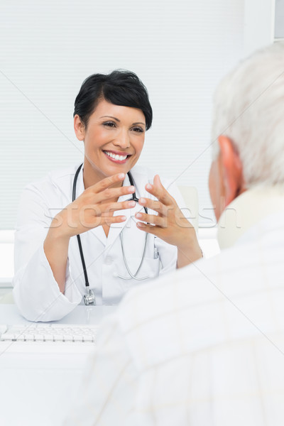 Young female doctor attentively listening to senior patient Stock photo © wavebreak_media