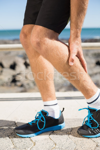 Stock photo: Fit man gripping his injured calf muscle
