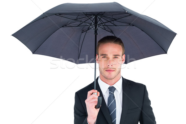 Unsmiling businessman sheltering under umbrella Stock photo © wavebreak_media