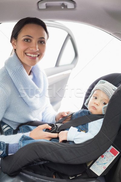 Mother securing her baby in the car seat Stock photo © wavebreak_media