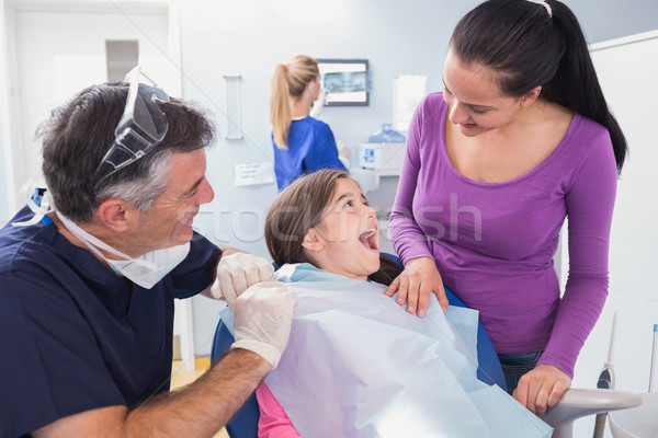 Smiling pediatric dentist with a happy young patient and her mot Stock photo © wavebreak_media