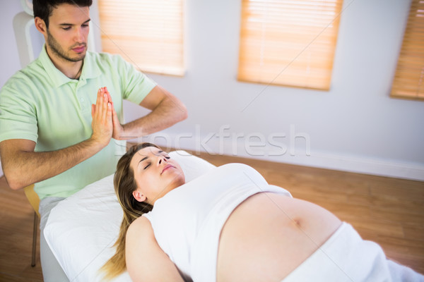 Relaxed pregnant woman getting reiki treatment Stock photo © wavebreak_media