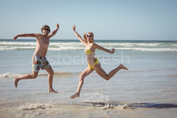 Wesoły para skoki brzegu plaży Zdjęcia stock © wavebreak_media