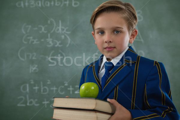 Iskolás fiú tart könyvek boglya alma tábla Stock fotó © wavebreak_media