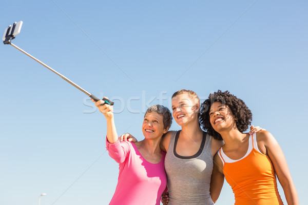 Smiling sporty women taking selfies with selfiestick  Stock photo © wavebreak_media