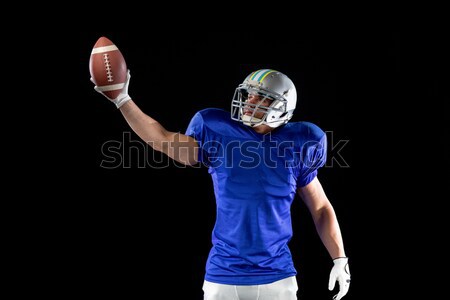 Stock photo: American football player cheering while holding ball
