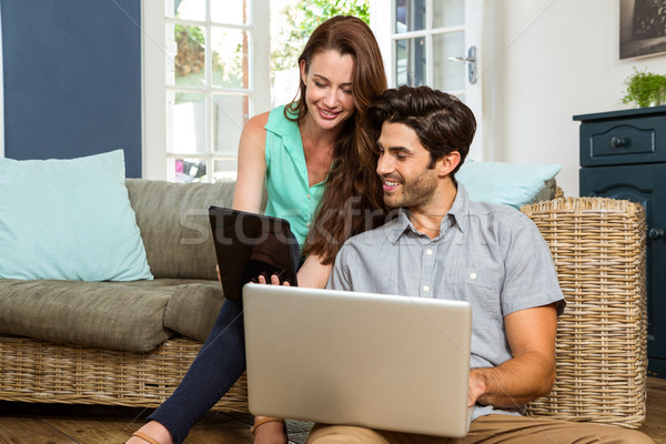 Couple using digital tablet and laptop in living room  Stock photo © wavebreak_media