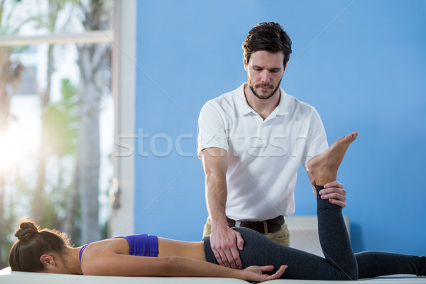 Male physiotherapist giving knee massage to female patient Stock photo © wavebreak_media