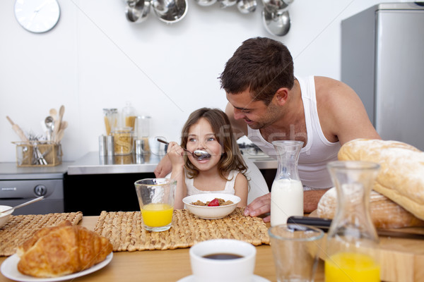 Daughter eating cereals and fruit for breakfast Stock photo © wavebreak_media