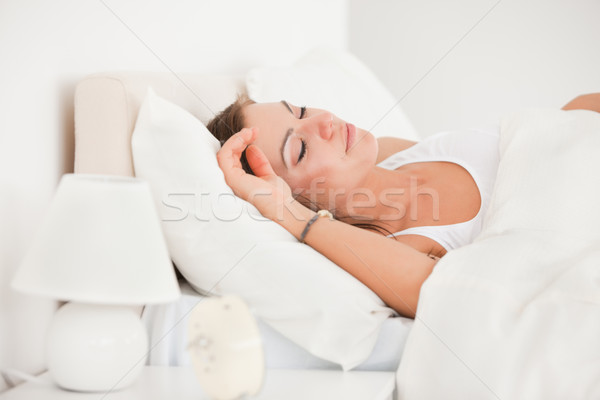 Young brunette sleeping in her bed against a white background Stock photo © wavebreak_media