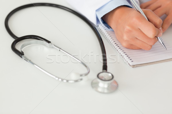 Female doctor writing on a scratchpad in her office Stock photo © wavebreak_media