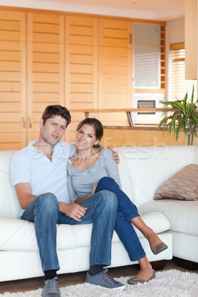 Portrait of a couple sitting on a couch while looking at the camera Stock photo © wavebreak_media