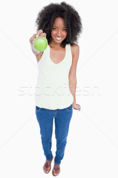Relaxed woman holding a green apple in front of her against a white background Stock photo © wavebreak_media